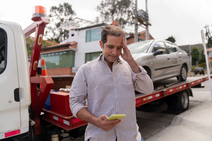 man's car being towed away